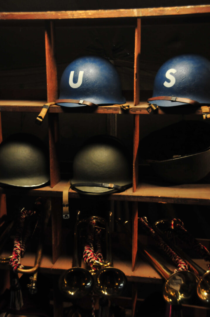 A shelf with helmets and bugles